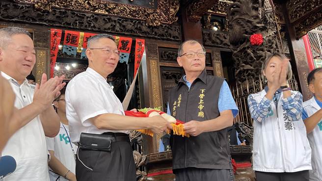 民眾党总统参选人柯文哲（左二）到下营区北极殿玄天上帝庙参拜，庙方致赠代表好彩头的菜头祝福。（张毓翎摄）