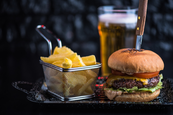 這名病患表示連2天吃了分量很大的漢堡加上2罐啤酒、薯條，結果腹痛衝急診。(示意圖，達志提供)