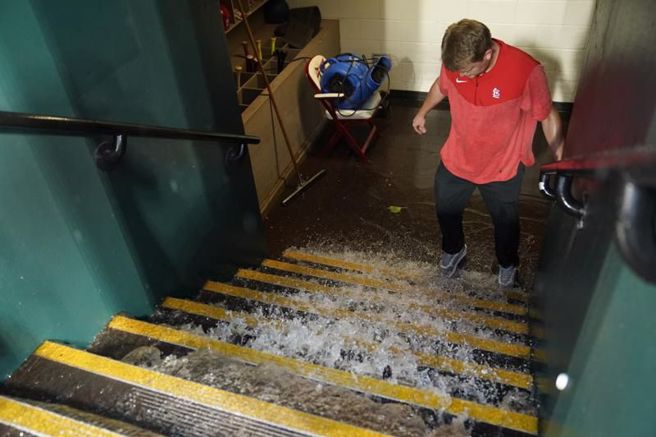 雨水從紅雀板凳區一路流向球員更衣室。（美聯社）