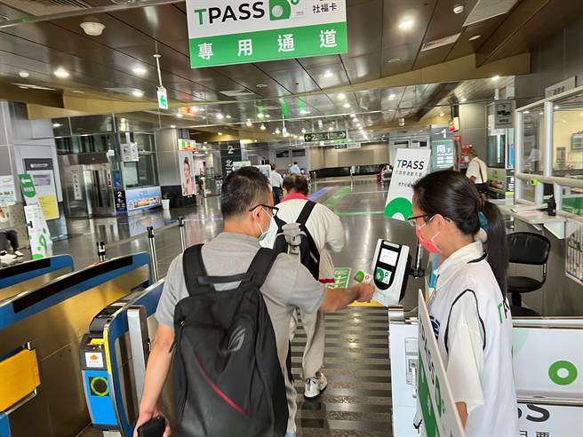 今日是南高屏999通勤月票上路後遇首上班日，民眾持卡通過月票專用車站，一旁有台鐵局人員提供協助。（崔正綱攝）