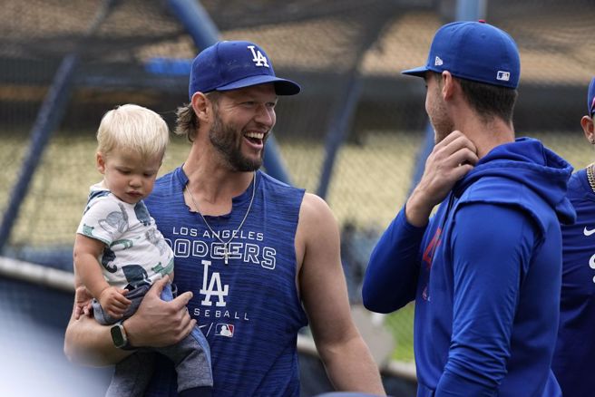 道奇球星柯萧(左)抱着小孩和前队友贝林杰聊天。（美联社资料照）