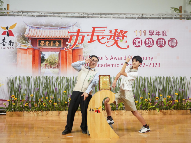 伟哲忍着腰伤不适，坚持与学生合照的行动，更是获得家长与学生一致好评。(戴志扬翻摄)