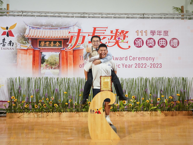 伟哲忍着腰伤不适，坚持与学生合照的行动，更是获得家长与学生一致好评。(戴志扬翻摄)