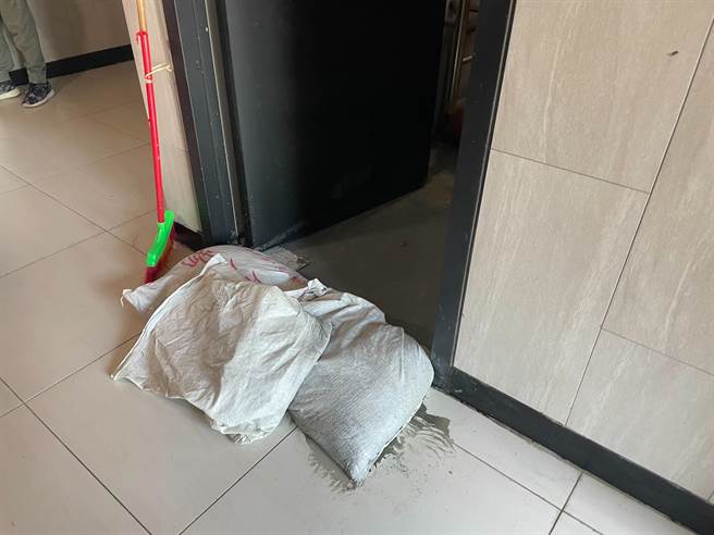 台北市大同区6月30日降下豪大雨，顶楼走道上的门和顶楼的水箱机房外都堆满沙包，水箱机房不断漏水，2处水源匯集流到电梯内，导致电梯故障需紧急断电检查。（刘彦宜摄）