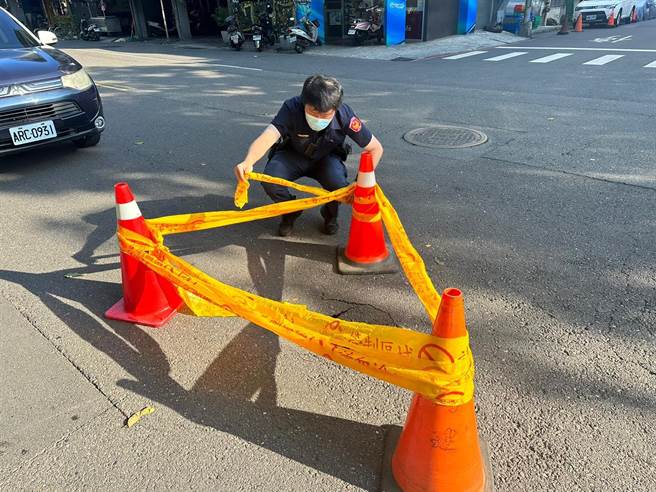 高雄凤山区区光华、国昌路口出现直径约30公分坑洞，警方急摆三角锥并拉起封锁线，避免民眾靠近。（市议员李雅静提供／崔正纲高雄传真）