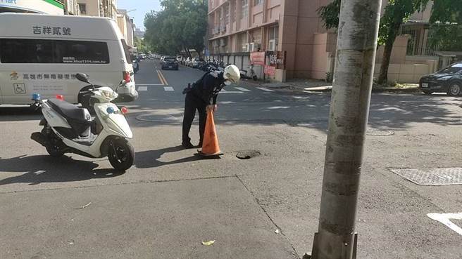 高雄凤山区区光华、国昌路口出现直径约30公分坑洞，警方急摆三角锥并拉起封锁线，避免民眾靠近。（市议员李雅静提供／崔正纲高雄传真）