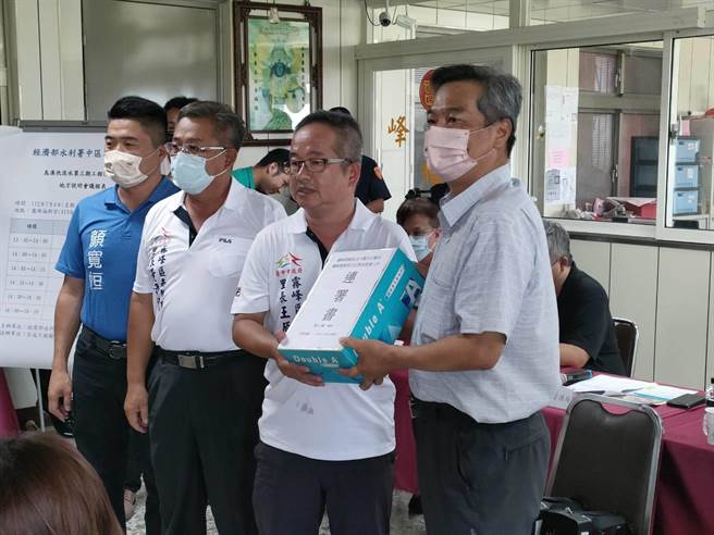 經濟部水利署中區水資源局4日於霧峰福新宮辦理烏溪伏流水第3期工程地方說明會，六股里長王原祥（右二）送上民眾連署書給中水局副局長洪信彰（右一）。（潘虹恩攝）