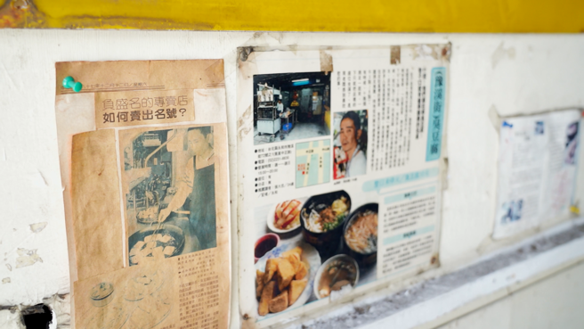 墙壁上贴着一张张报纸，纪录周伯伯的辉煌故事(图/林荷玉 摄)