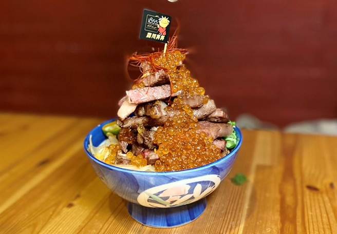 森川丼丼的「排山倒海丼」更是浮夸到令人尖叫，选用带鲜美油花的 1855 美国特级安格斯牛小排，铺在铺满葱花的白饭上，直接在丼饭上淋上满满鲑鱼。（冯惠宜摄）