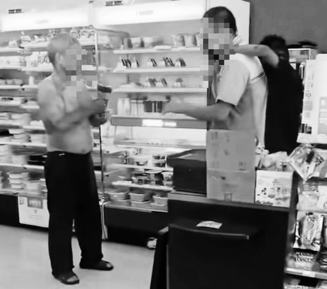 行凶男子见其子躲到超商店员后方，仍手拿榔头不发一语直视前方。（翻摄脸书爆废公社二馆／孙英哲彰化传真）