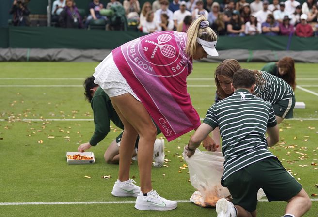 英国选手包特帮忙清理球场。（美联社）