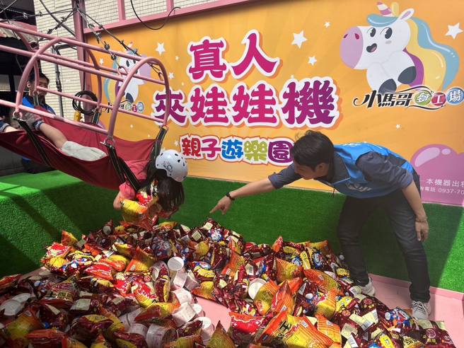 台中市议员罗廷玮（右）准备人体夹娃娃机，供今年度考过满分的小朋友们免费体验。（图／翻摄自罗廷玮脸书）