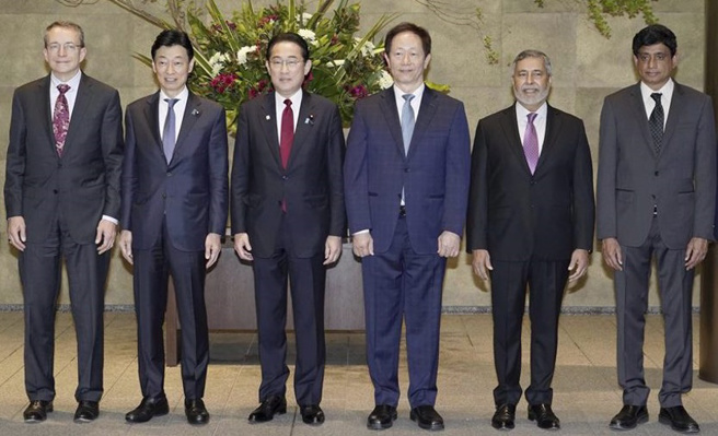 日本首相岸田文雄（左三）、日本經濟產業大臣西村康稔（左二）與台積電董事長劉德音（右三）、英特爾執行長季辛格（左一）等全球半導體大咖合照。（圖／美聯社）
