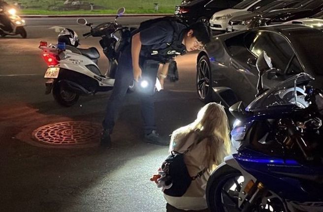 警方获报到场女骑士蹲地哭泣。（图／民眾提供）