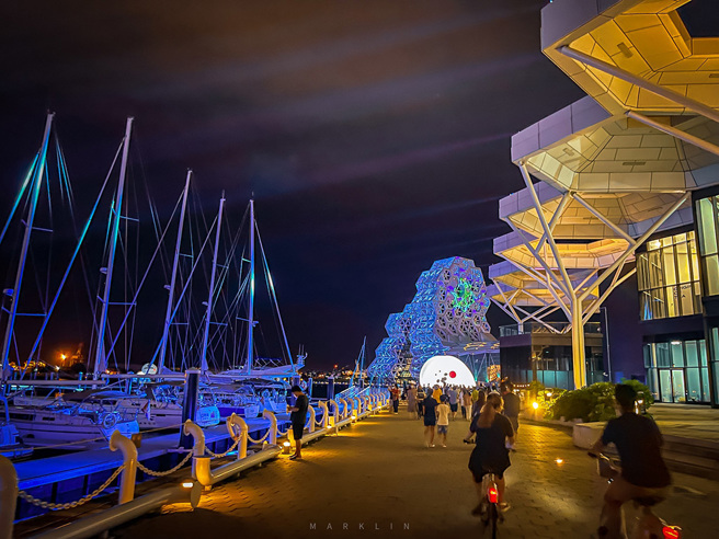 華燈初上，高雄流行音樂中心沿岸運用不同燈光色彩點綴，為夜晚港都披上一層浪漫。(圖片提供/高市府海洋局)

