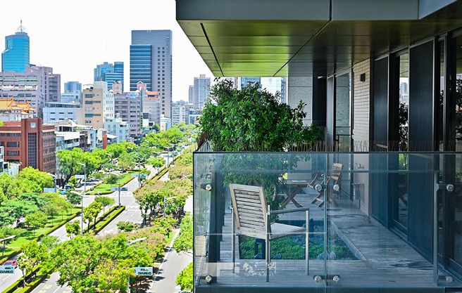 高雄厝住戶，同時也是建築師的楊豐溢，家中的高雄厝陽臺綠意與民生路樹海連成一片。(攝影/Carter)
