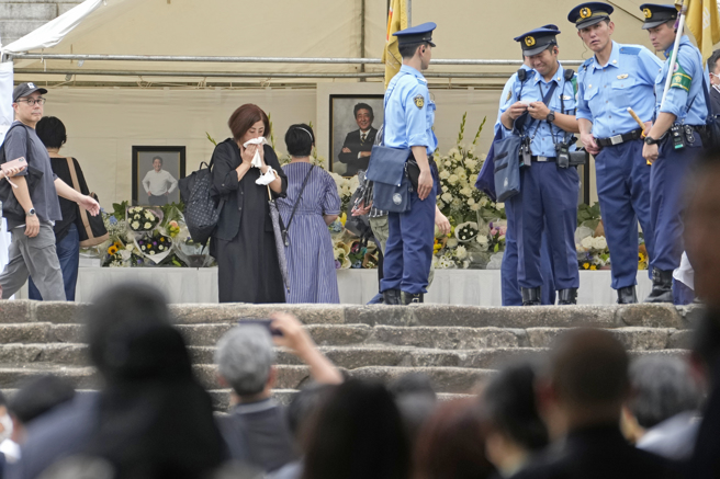 日本每日新闻报导，听到献花台附近有人叫喊「有男子手持铁管」后，引发现场一阵骚动。这名持铁管的男子被制伏后已遭警方带离，详细状况仍待警方进一步厘清。(图/美联社)