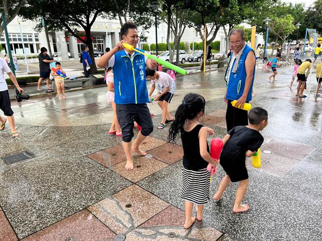苗栗市市民廣場從7月1起開放，苗栗市長邱鎮軍特別贈送水槍給小朋友消暑一下。（讀者提供／謝明俊苗栗傳真）