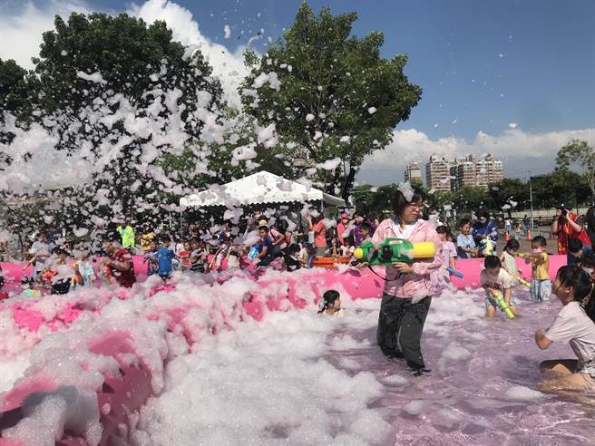 炎炎夏日飙高温，屏东市8日推出「夏日泡泡趴」消暑活动，数百名大小朋友在復兴图书馆前举起水枪玩水嗨翻天。（谢佳潾摄）