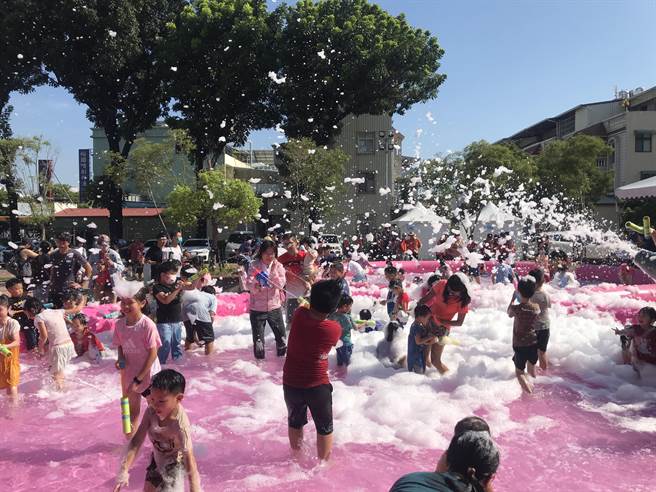 炎炎夏日飙高温，屏东市8日推出「夏日泡泡趴」消暑活动，数百名大小朋友在復兴图书馆前举起水枪玩水嗨翻天。（谢佳潾摄）