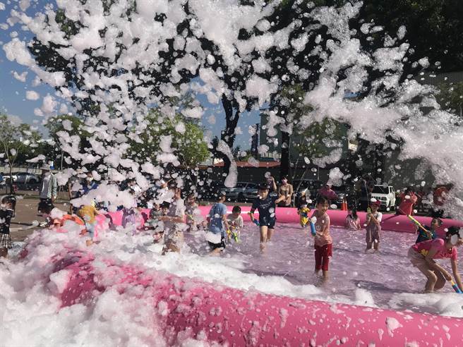 炎炎夏日飙高温，屏东市8日推出「夏日泡泡趴」消暑活动，数百名大小朋友在復兴图书馆前举起水枪玩水嗨翻天。（谢佳潾摄）