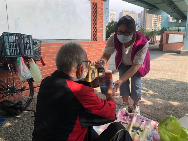 新北市街友外展服务中心社工到土城高架桥下送矿泉水及八宝粥给街友。（新北市社会局提供）