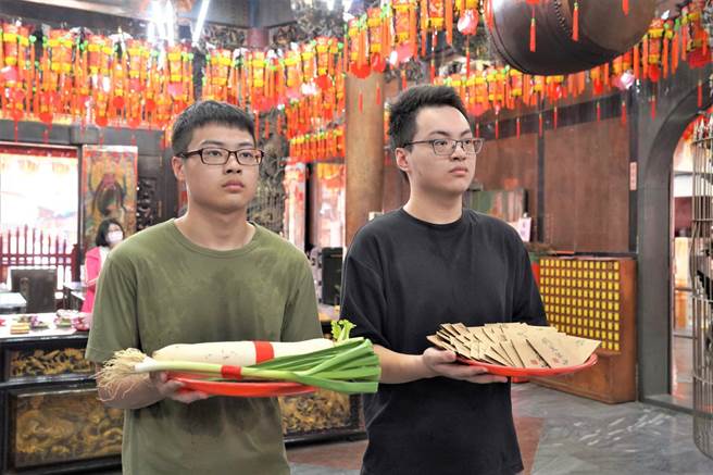 考生持铁定包种茶、葱参拜文昌帝君，祈求考试包中好学校。（新北市政府提供）
