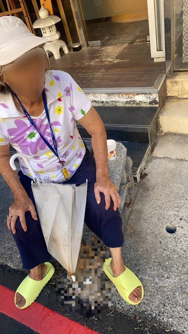 妇人中暑身体不适坐于路旁，幸遇热心警民及时救援。（翻摄照片／林郁平台北传真）