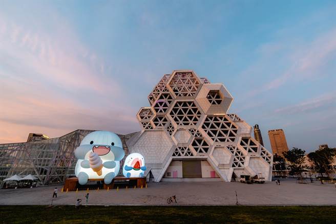 「胖鯊魚鯊西米」來了啦，在雪白高流音浪塔前，吃冰淇淋和西瓜的萌樣，實在很夏天。（擷取陳其邁臉書／柯宗緯高雄傳真）