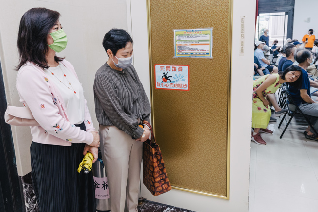 「美國在台協會」（AIT）台北辦事處的擴建，鎖定內湖中學金湖校區2.6公頃的國中用地，擬變更為機關用地租給AIT使用，12日舉行都市計畫變更草案公開展覽前座談會時遭到地方里民普遍反對，AIT現場有人員到場旁聽，市議員現場要求AIT的人上台發言說明，而該民AIT代表（左一）則不願透露職稱頭銜，也聲稱未授權發言，僅在門口聆聽座談會內容。(郭吉銓攝）