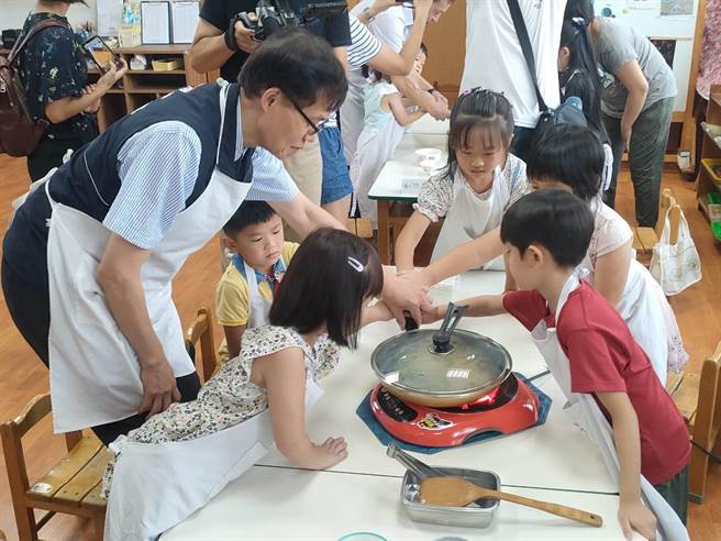 台中市政府教育局长蒋伟民13日前往岸里国小附幼视察暑期上课情形，并和孩童一起爆米花。（潘虹恩摄）