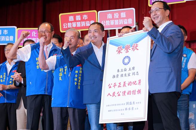 国民党总统参选人、新北市长侯友宜（右二）13日出席中华民国公教军警消联合总会会员大会，国民党主席朱立伦（右一）送上荣誉状。（黄世麒摄）