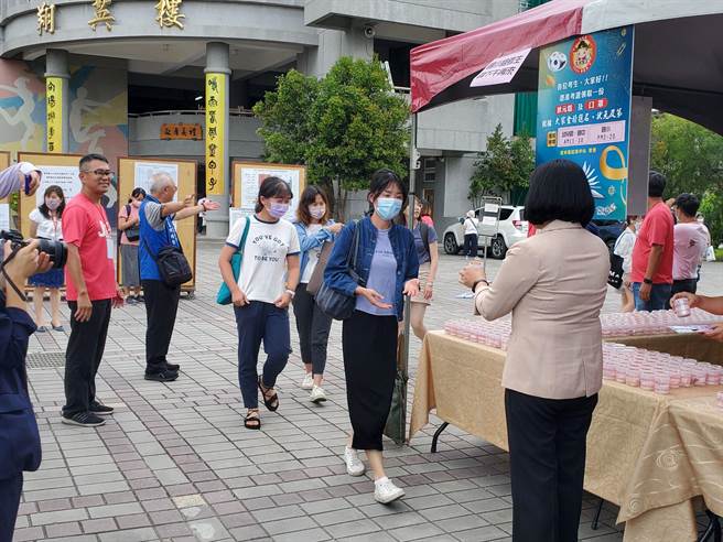 云林县长张丽善（背影）逐一分送状元糕祝福有缘的考生们加入云林公职大家庭。（周丽兰摄）