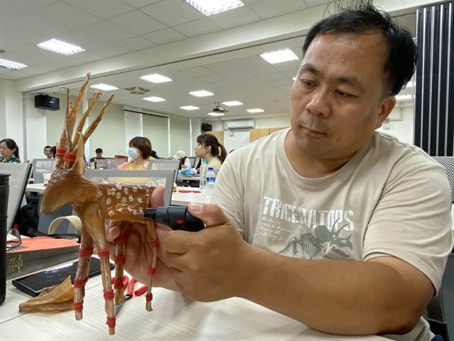 學員們用防風打火機，在以魷魚乾做成的梅花鹿身上瞬間燒出白花點。(于家麒攝)