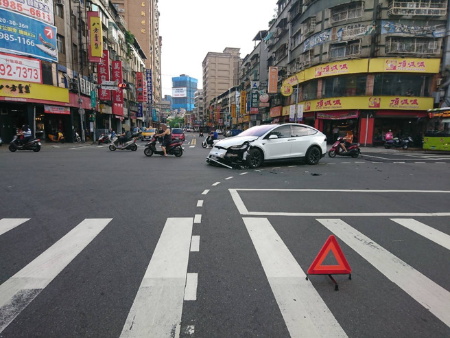 新北市1名李姓男子駕駛特斯拉到路口時準備左轉，遭對向直行的計程車撞上，前保險桿當場被撞壞掉落，李男左手也受到輕傷送醫。（圖／警方提供）