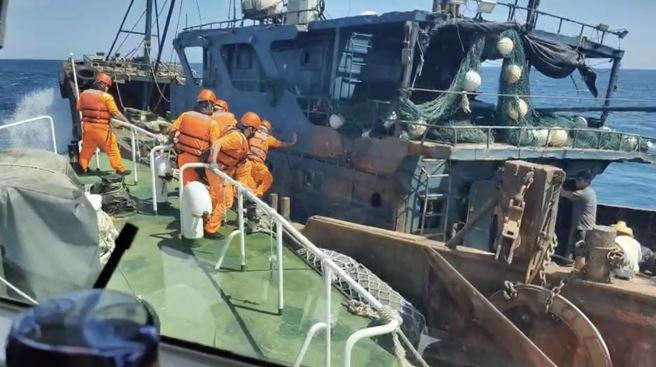 大陸籍漁船進入我國限制水域拖網作業，經多次鳴笛廣播命其停俥受檢，均拒不停船，海巡隊緊追後強靠登檢該陸船。（圖／海巡署提供）