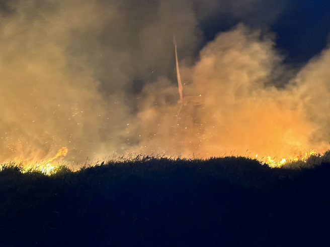新北市石门晚间发生田野火警，十八王公庙旁的边坡疑似因爆竹引发火势。（消防局提供）