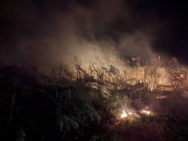 新北市石门晚间发生田野火警，十八王公庙旁的边坡疑似因爆竹引发火势。（消防局提供）