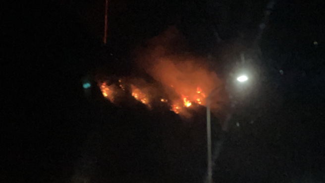 新北市石门晚间发生田野火警，十八王公庙旁的边坡疑似因爆竹引发火势。（消防局提供）