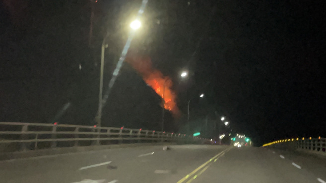 新北市石门晚间发生田野火警，十八王公庙旁的边坡疑似因爆竹引发火势。（消防局提供）