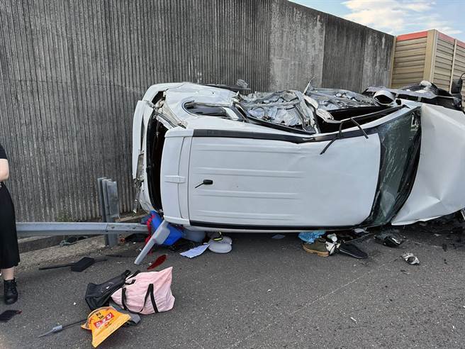 国道一北上台南仁德段1辆白色休旅车，疑因闪避另辆突然变换车道的休旅车，失控撞上外侧护栏后侧翻。（读者提供／洪荣志台南传真）