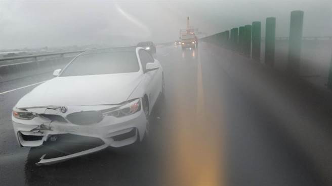 白色BMW自撞内侧护栏，车头毁损。（读者提供／张毓翎台南传真）