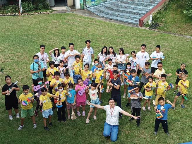 台中新社地区三所小学的孩子各自拿着自己手做的乌克莉莉和志工团队合影。（音乐园丁团队提供）