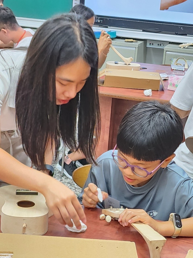 志工姊姊细心的教着孩子自制乌克莉莉。（音乐园丁团队提供）