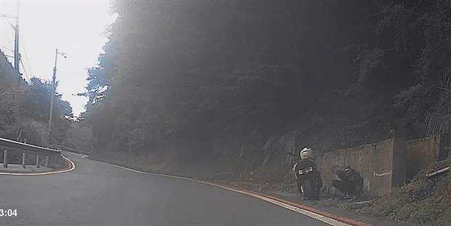 男子騎車環島半圈，因體力不繼感到頭暈，蹲坐路旁休息。（警方提供／陳淑娥台中傳真）