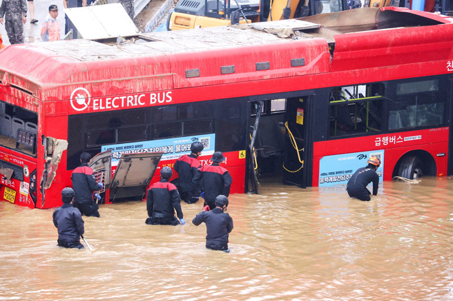 南韩忠清北道747路线公车因大雨改道，行经五松地下道时不幸灭顶，酿成司机、乘客等多人死亡。图为16日公车被拖出地下道、车身沾满淤泥的画面。（图／路透社）