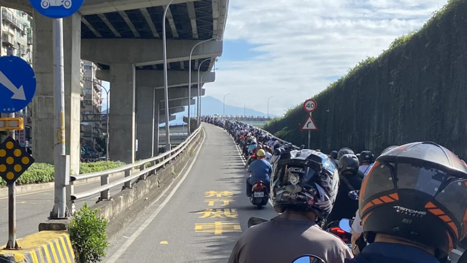 一名女网友日前从三重河堤骑车上台北桥，机车引道排满待上桥的骑士。（图／网友授权提供）