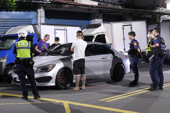 张男（图中白衣者）自称路人，却又称车钥匙不见踪影，说词反覆，警方将人带回调查。（黄世麒摄）