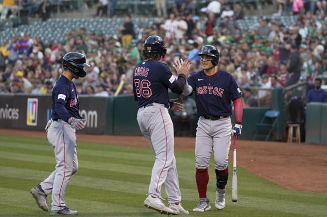 红袜卡瑟斯(中)与队友张育成击掌。（美联社）