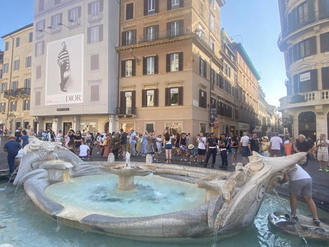欧洲热浪来袭，义大利首都罗马闷热的天气让许多民眾和游客待在喷泉旁消暑。图为西班牙广场旁着名的巴卡恰喷泉（Fontana della Barcaccia）。（图/中央社）